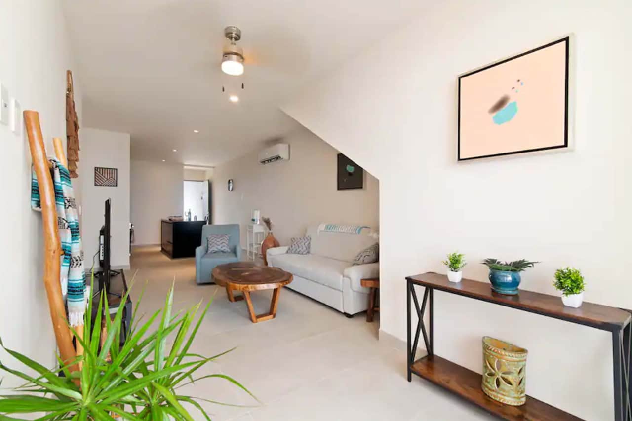 Stylish living room: Art, AC, ceiling fan, versatile couch-bed. Perfect retreat for relaxation.