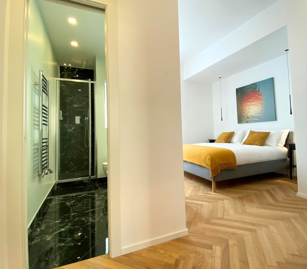 Master bedroom with king bed, en-suite and modern decor.