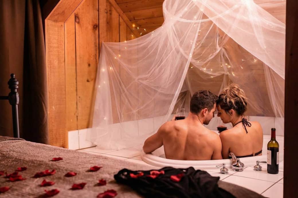 Romantic Heart shaped soaking tub with lights and canopy above sets a magical mood |