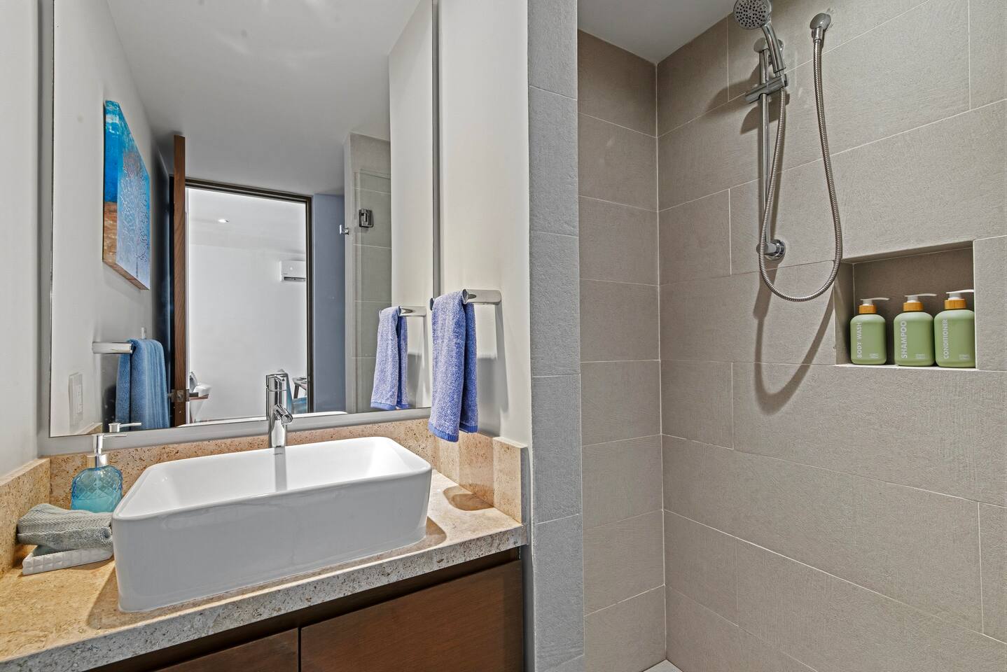 Disfrute de un cómodo baño con ducha a ras de suelo, toallas frescas, champú, acondicionador y jabón, todo lo que necesita para una estancia cómoda y relajante.