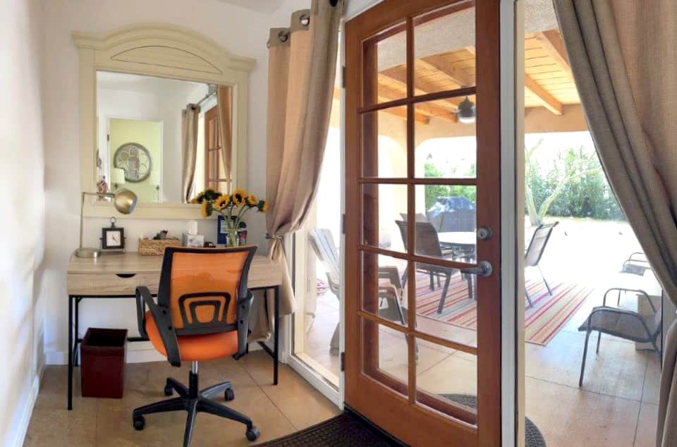 Office that leads to back patio filled with natural light.