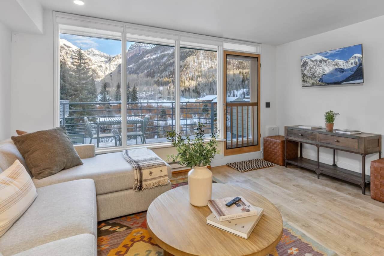 Living room w/ TV and door to deck