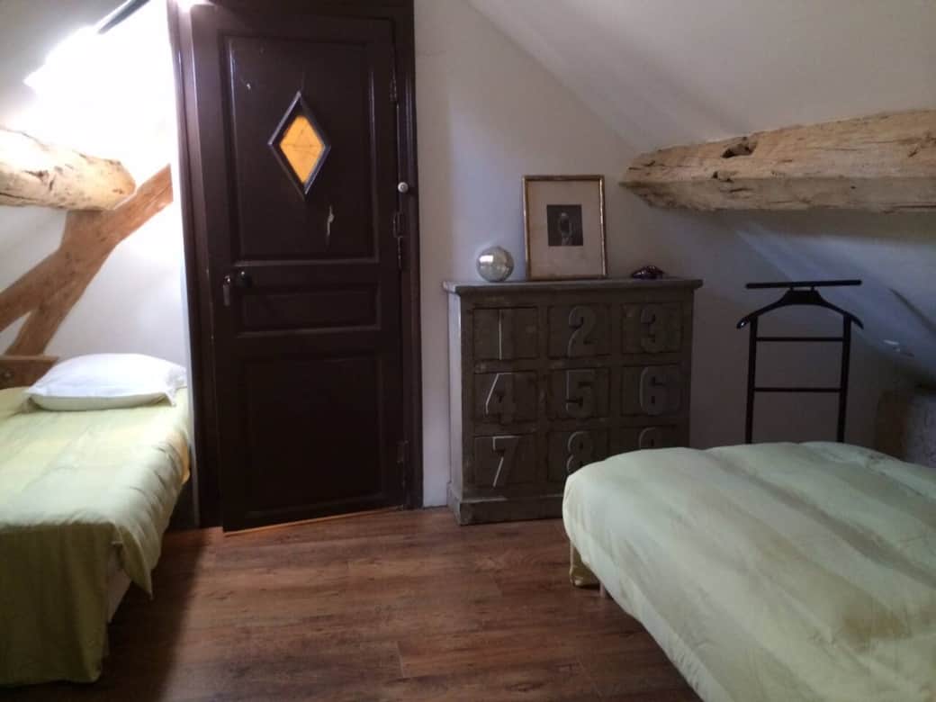 Petite chambre mansardée avec 2 lits.