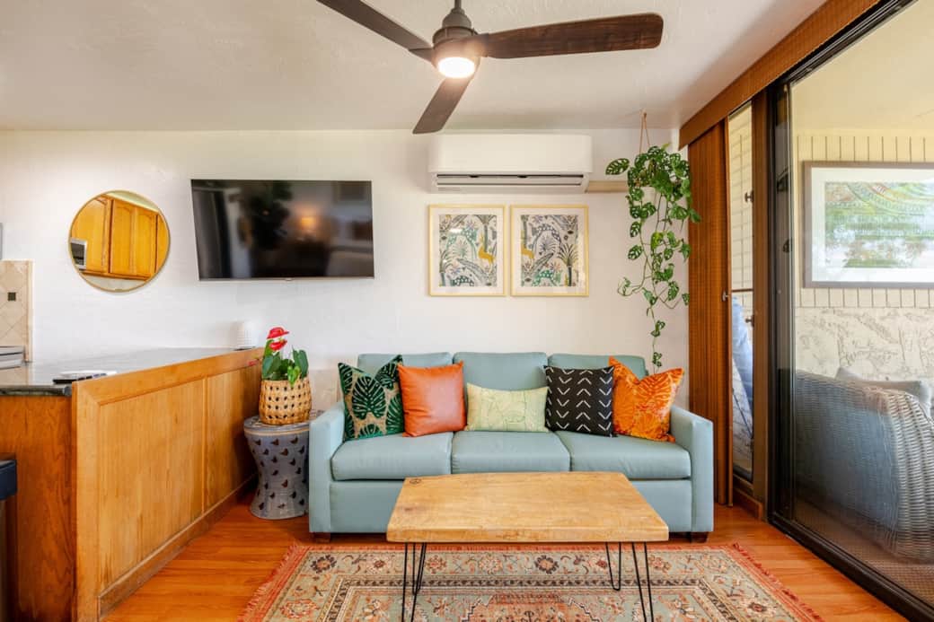 Living room featuring a comfortable sofa and air conditioning—perfect for staying cool on warm Hawaiian days.