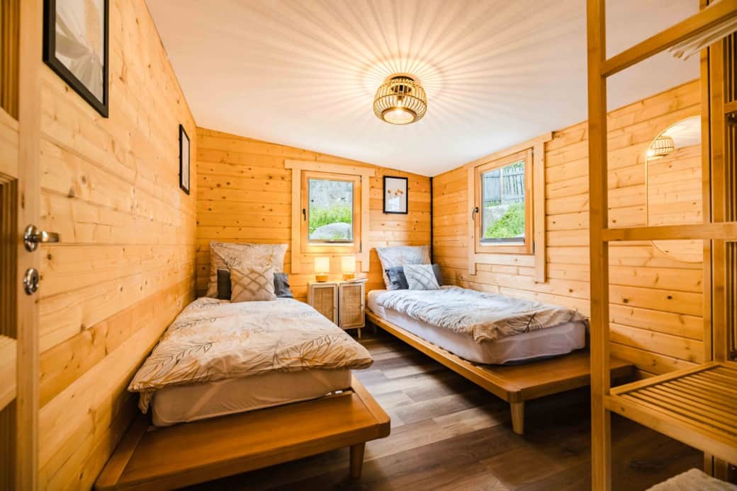 Chalet Oz twin bedroom with wooden walls, warm lighting and mountain-inspired cozy design Chalet Oz twin bedroom with wooden walls, warm lighting and mountain-inspired cozy design