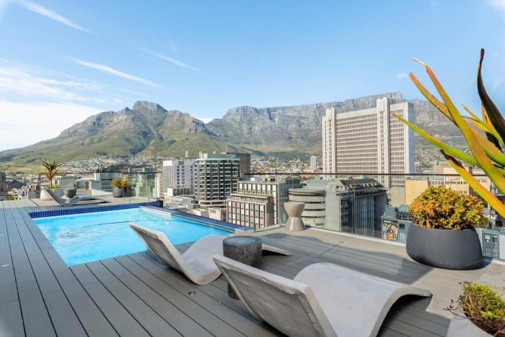 Decked infinity rooftop pool with expansive city views 