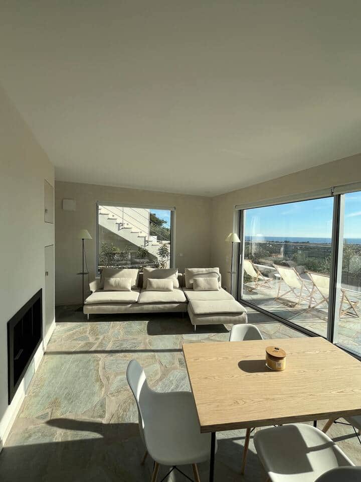 Comfortable living room with open views, direct terrace access and natural light. An open, luminous living space where stone and volume breathe together - generous seating, open horizon, an invitation to absolute calm.
