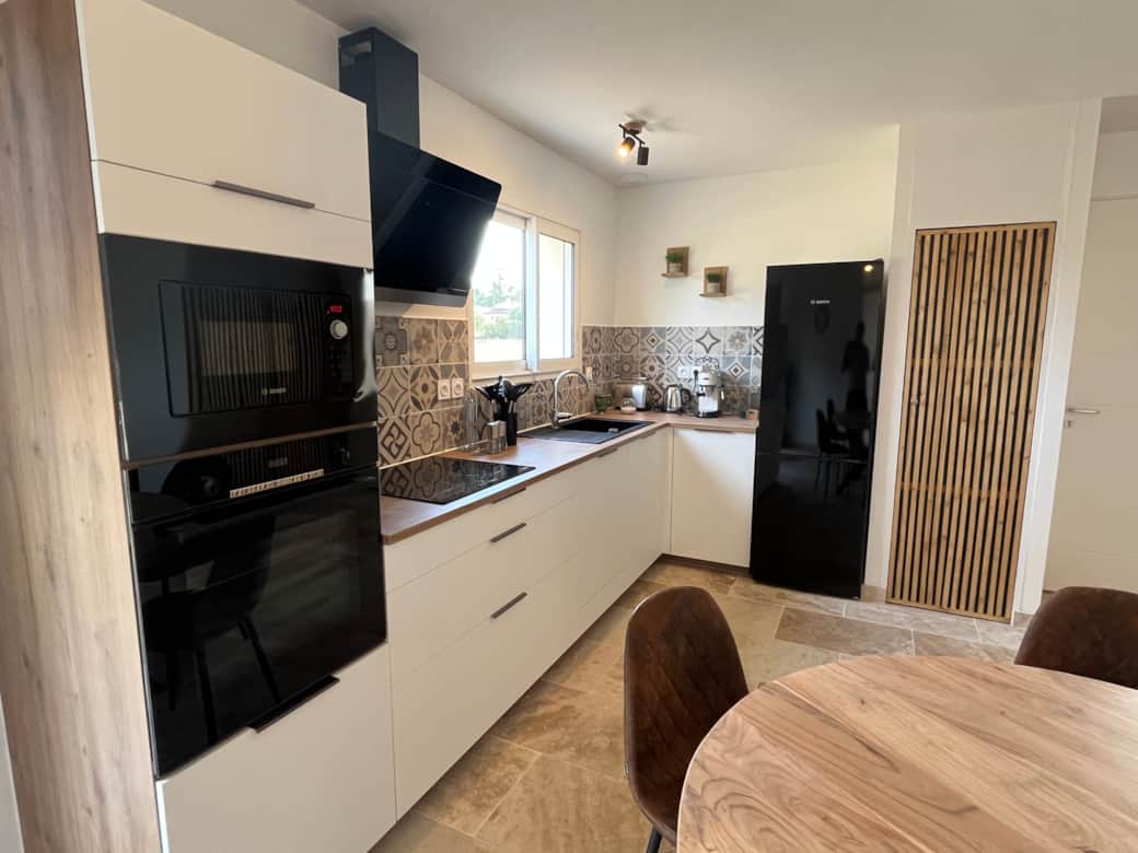 The modern kitchen is equipped with an espresso machine and other brand-name appliances. 