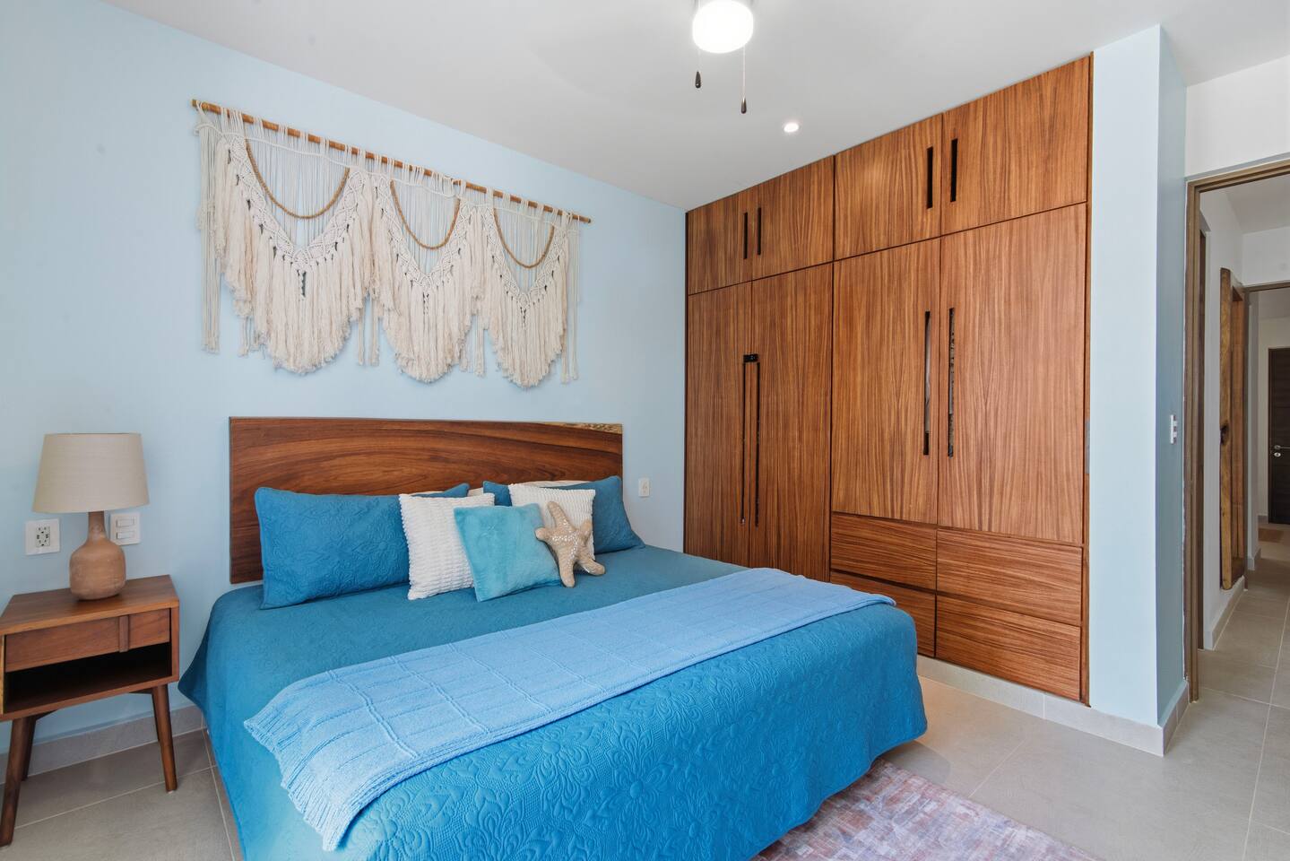 El dormitorio principal no solo ofrece vistas al Mar Caribe, una cama king, Smart TV, aire acondicionado, ventilador de techo, armario, cortinas opacas y acceso directo al balcón, jacuzzi y jardín, sino que también cuenta con interruptores y tomas de corriente junto a la cama para iluminación y carga.