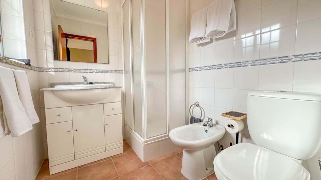 The attached bathroom has a shower, bidet, and vanity.