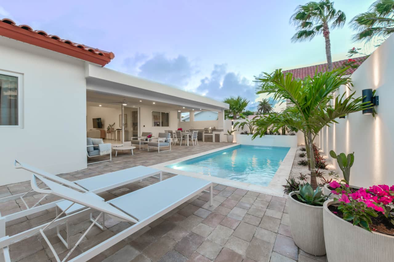 Private backyard with sun loungers and covered lounging, dining, and BBQ areas