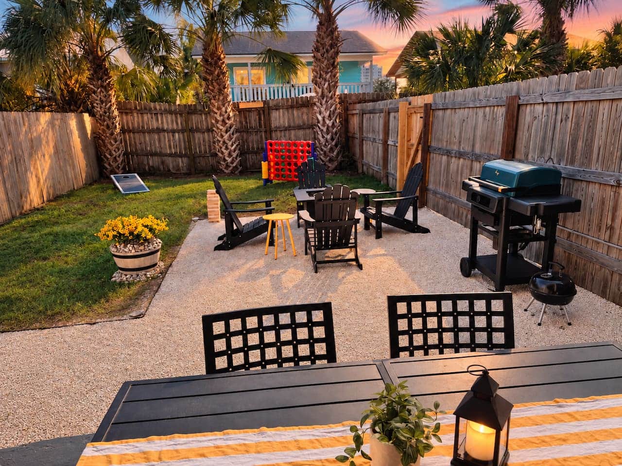 Unit B's fenced backyard brings everyone outside for BBQ meals, cornhole, giant four-in-a-row, and evenings around the fire pit. Enjoy a covered dining patio, palm trees, and a connecting gate to Unit A's yard when you book the full duplex