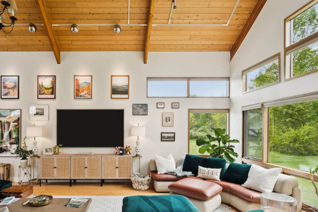 The great room features mountain views, 2 couches, large flat screen TV, game table, & grand piano.