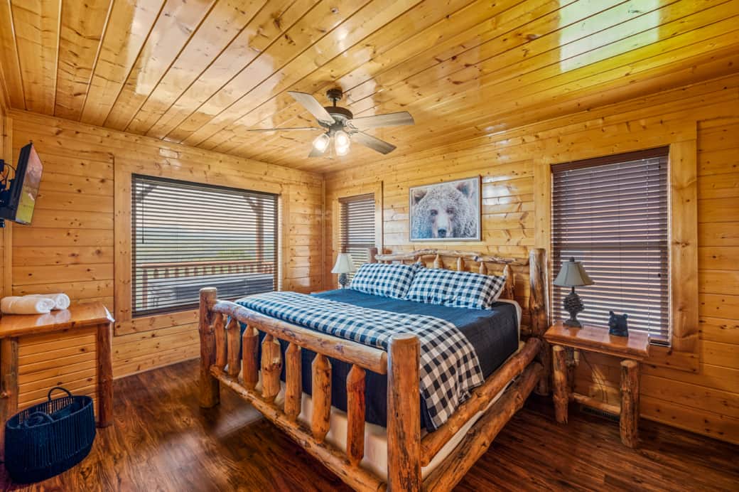 Private king bedroom on the lower level of the cabin, equipped with flatscreen TV & private bathroom