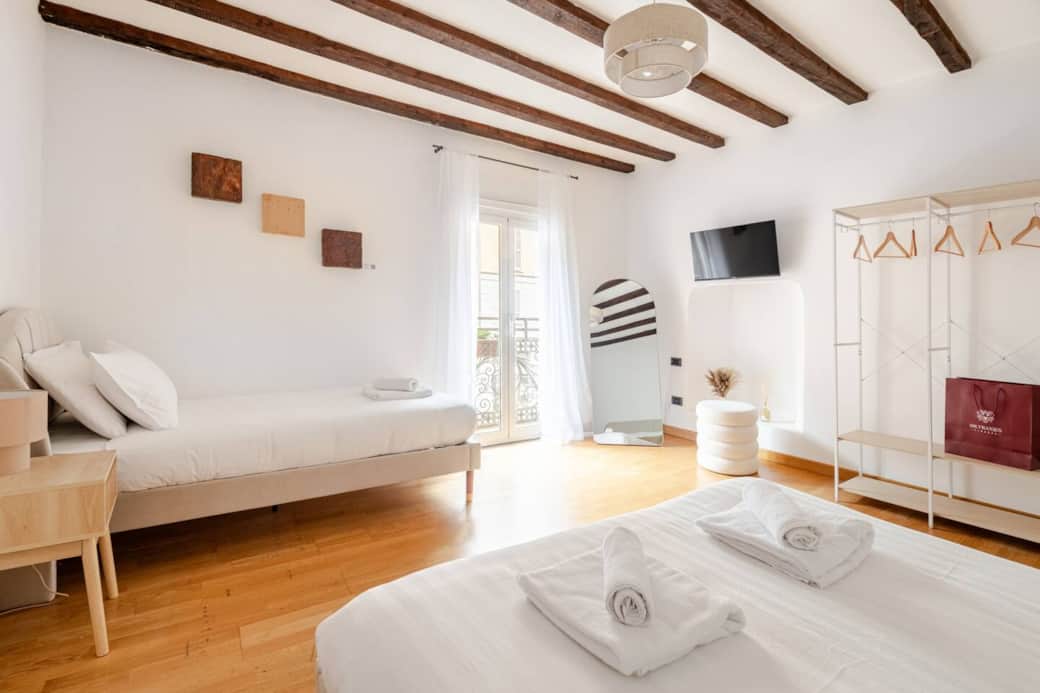 Camera da letto con letto matrimoniale e letto singolo, con tv e balcone