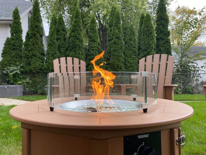 Spacious backyard with a cozy fire pit seating area and BBQ grill