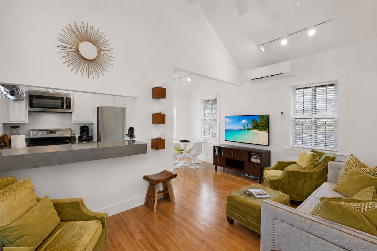 Open living area with smart TV, dining nook, vaulted ceiling, and kitchen flow.