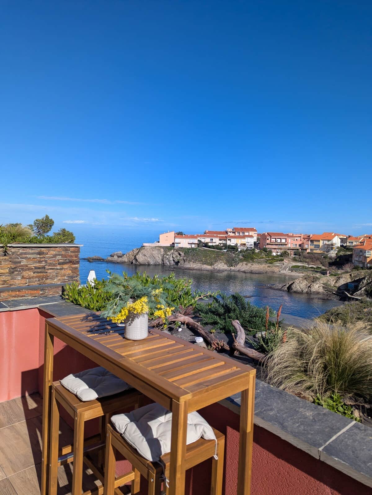 Terrace with bar table enjoying view of the creek/cove and sea.