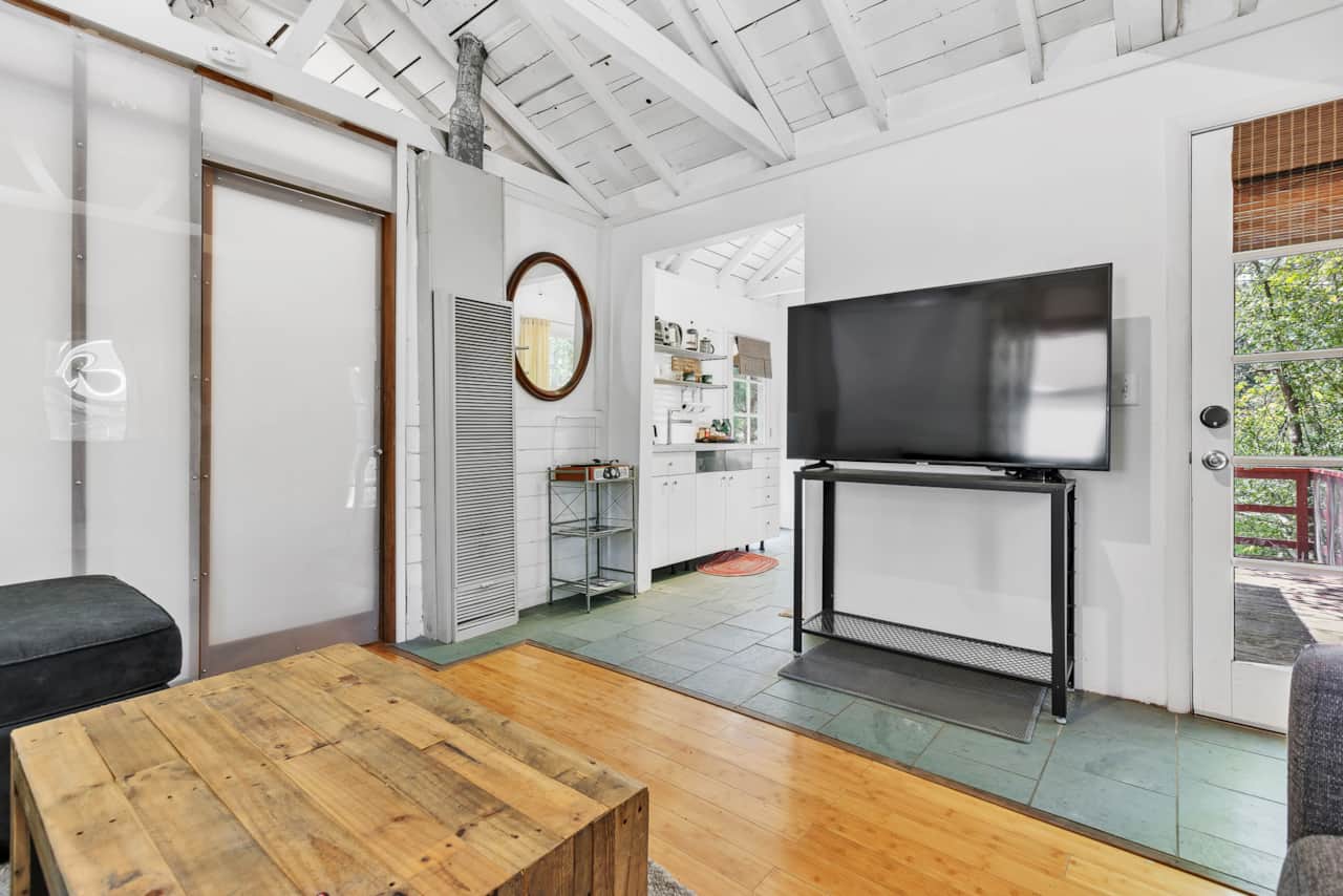 Savor natural light in the cabin’s living room, relax on a cozy sofa bed, and enjoy TV.
