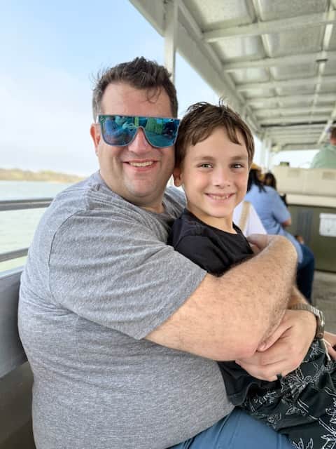 Father and son hugging during a ferry ride in Galveston