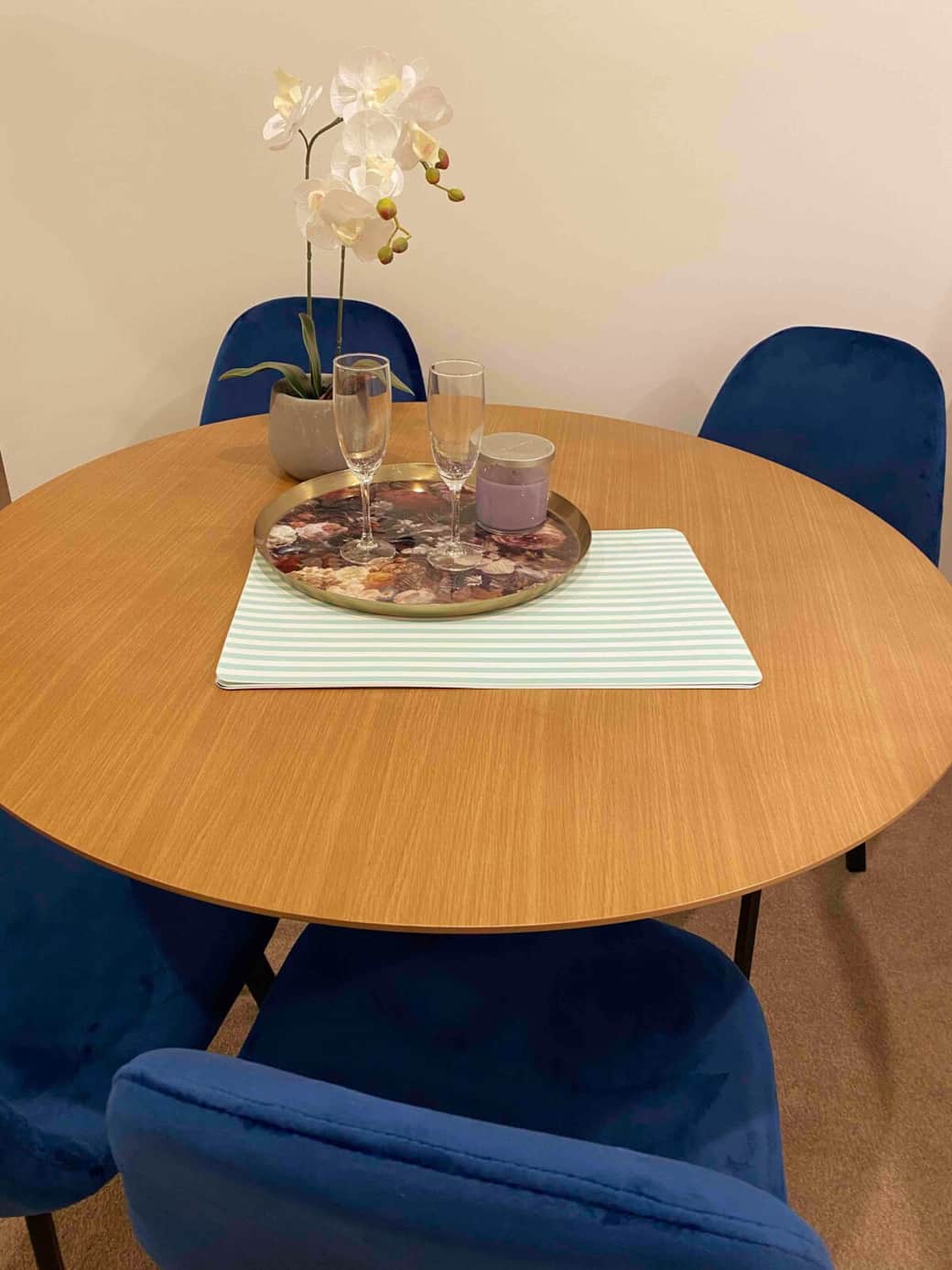 Dine in comfort with our charming dining setup. The round table, surrounded by vibrant blue chairs, offers a cozy space for meals. The elegant centerpiece adds a touch of sophistication, creating an inviting atmosphere for shared meals .