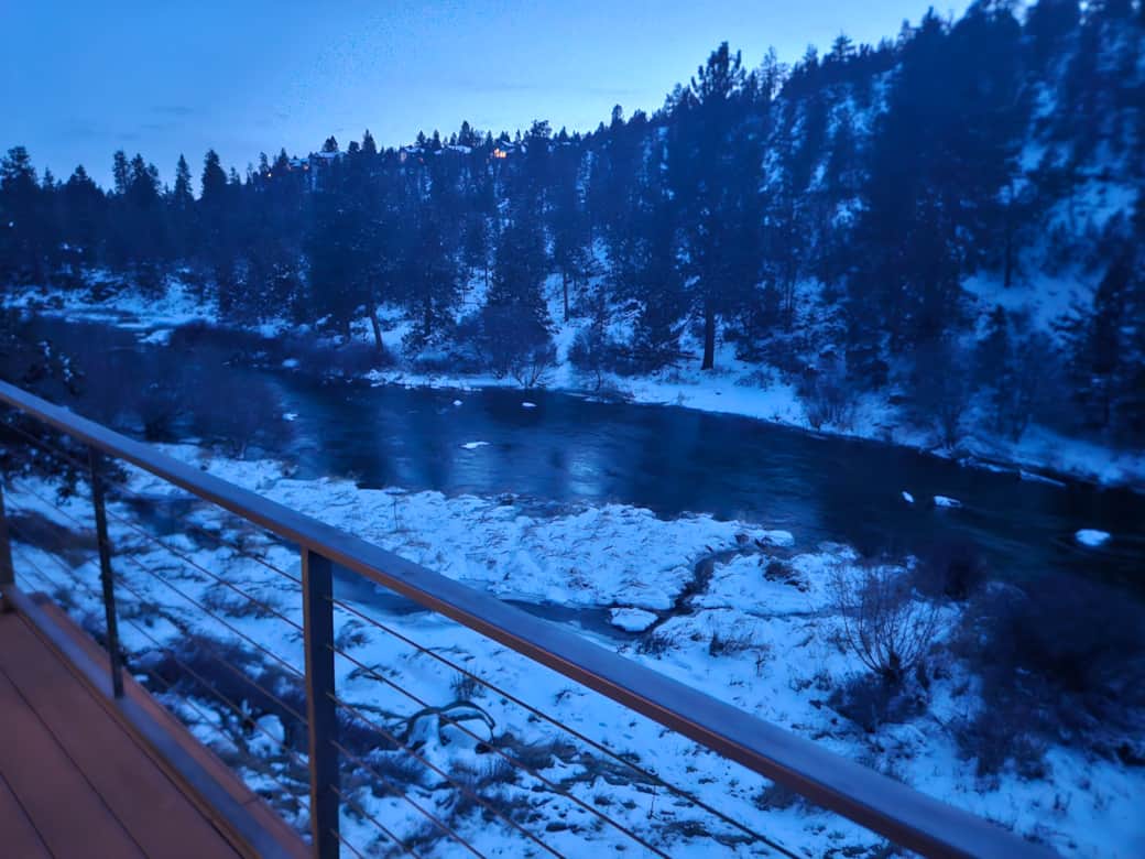 View of snowy river from main level deck 