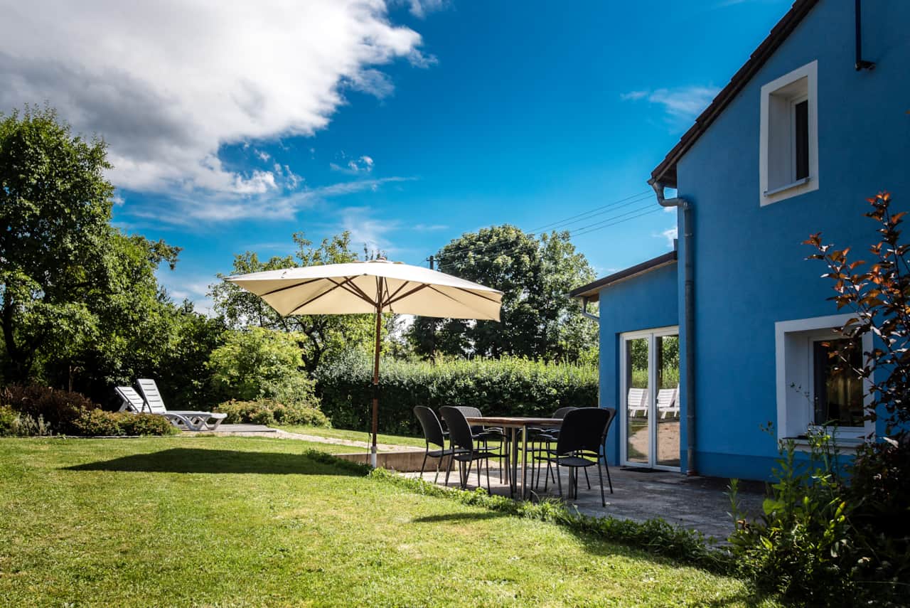 Veranda mit Holzkohlegrill und Sonnenschirm