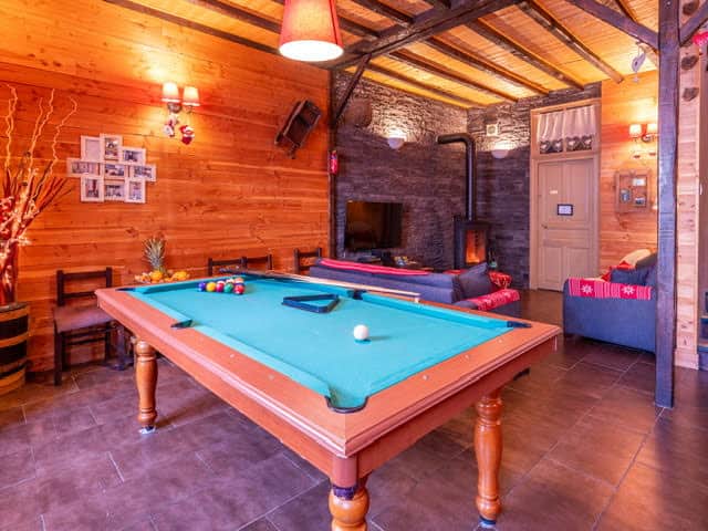 Grand salon 50m² avec billard poêle à bois et canapés