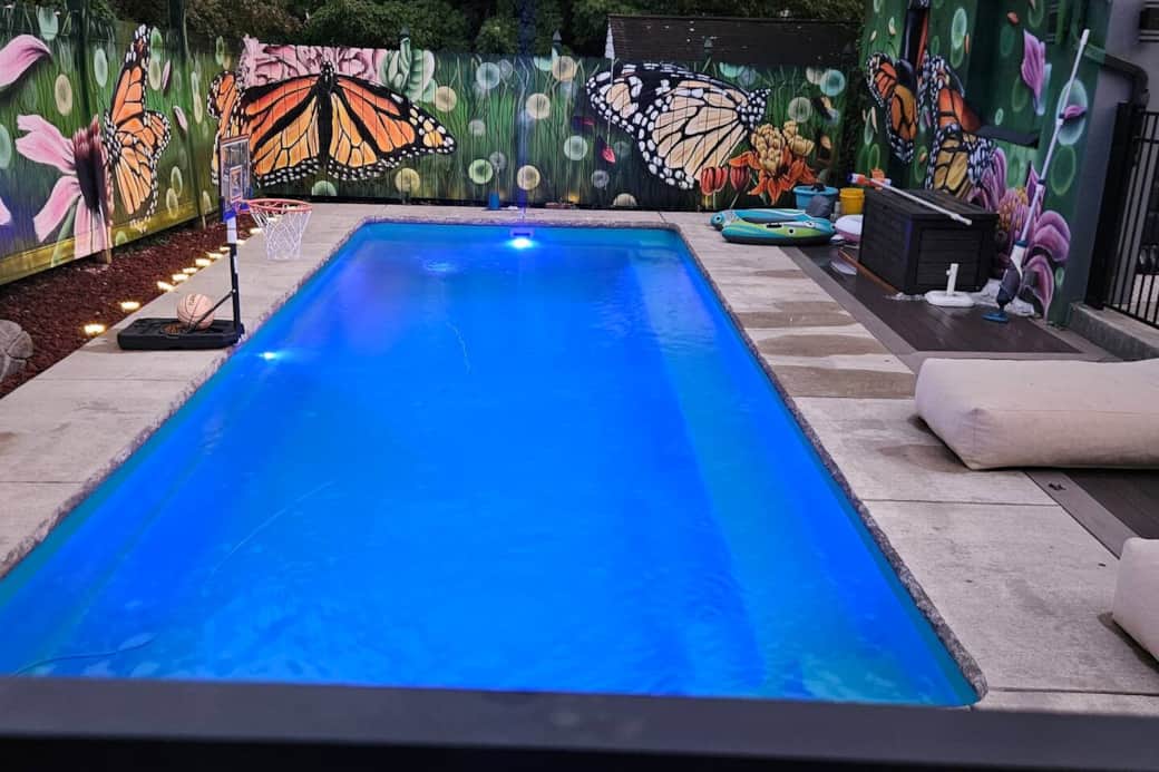 The custom painted butterfly and flower mural adds so much whimsy and fun to the beautiful pool area