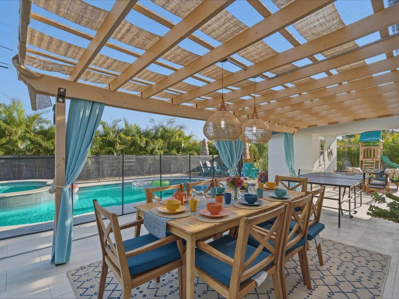 Pergola-covered dining area overlooking the pool