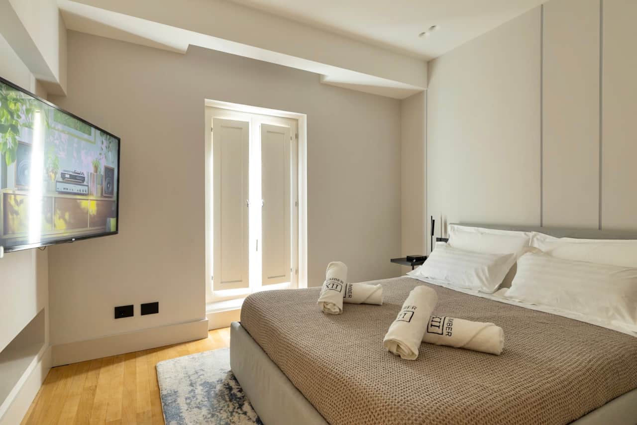 Bedroom 1 complete with king-sized bed, shutters and a large Smart TV