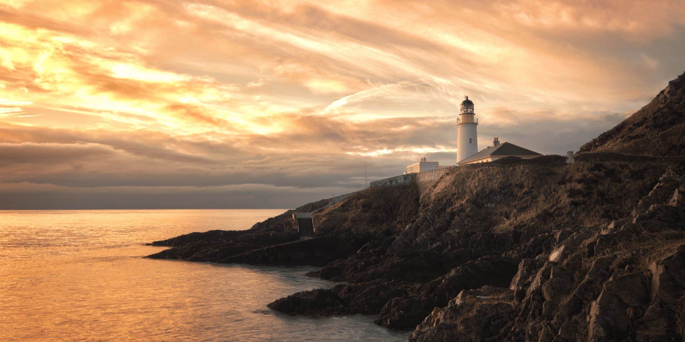 A lighthouse on the Isle of Man coast at dusk