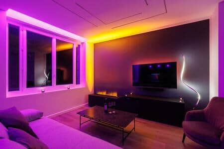 Salon de nuit avec cheminée à vapeur d’eau et lumières d’ambiance couleurs purple