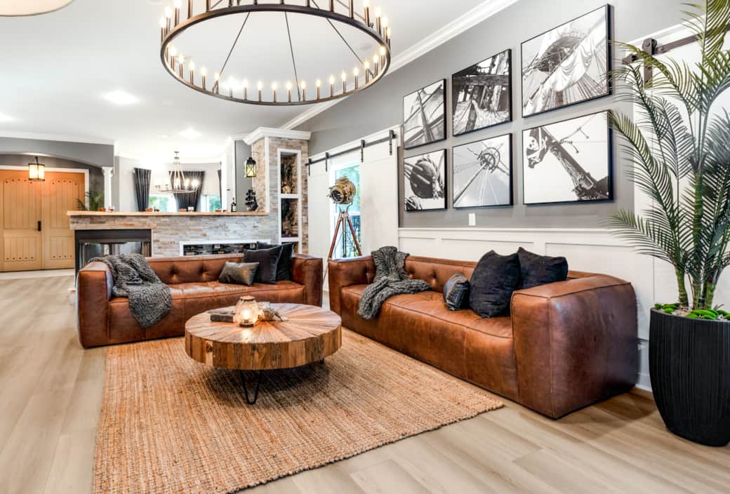 Warm and inviting living room with leather sofas, nautical art, and a rustic wood coffee table. Warm and inviting living room with leather sofas, nautical art, and a rustic wood coffee table.