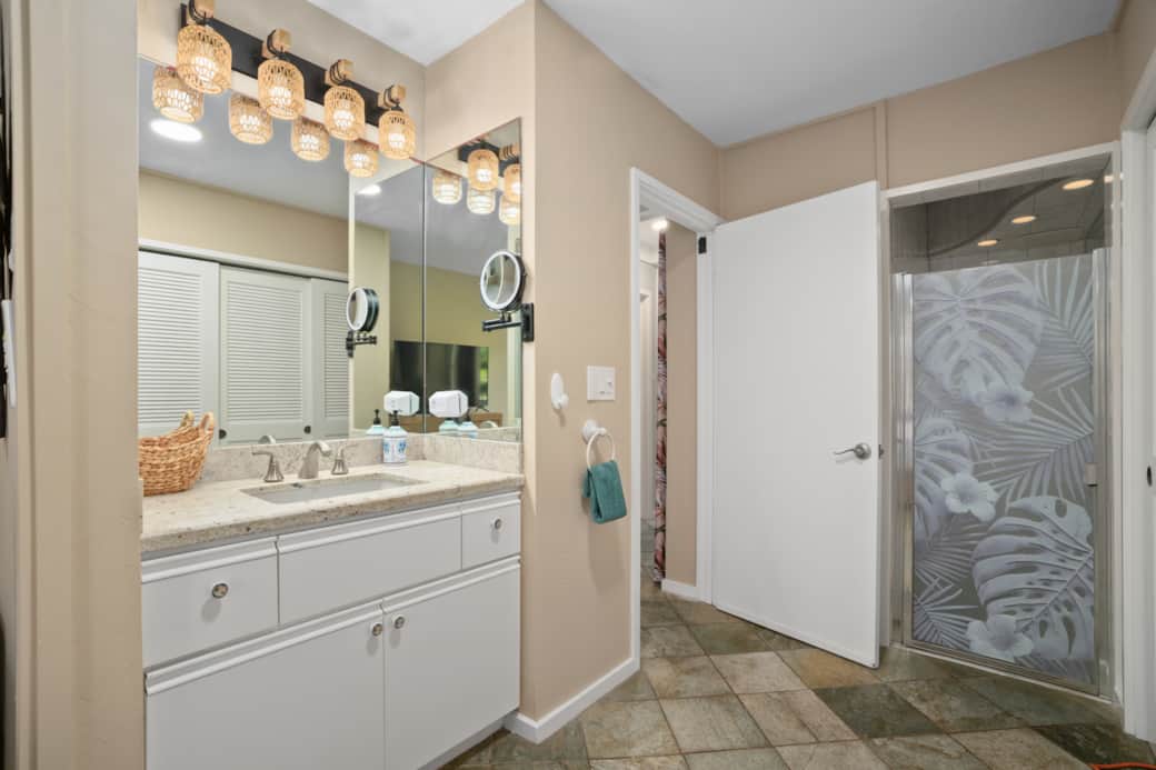 Spacious bathroom with dual vanity and tropical-style shower.