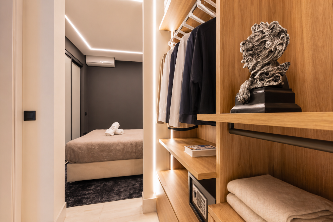 Rental12 Olbia, modernes begehbares Kleiderschrank-Schlafzimmer mit Blick auf das Schlafzimmer, Holzregale zum Aufhängen von Kleidung