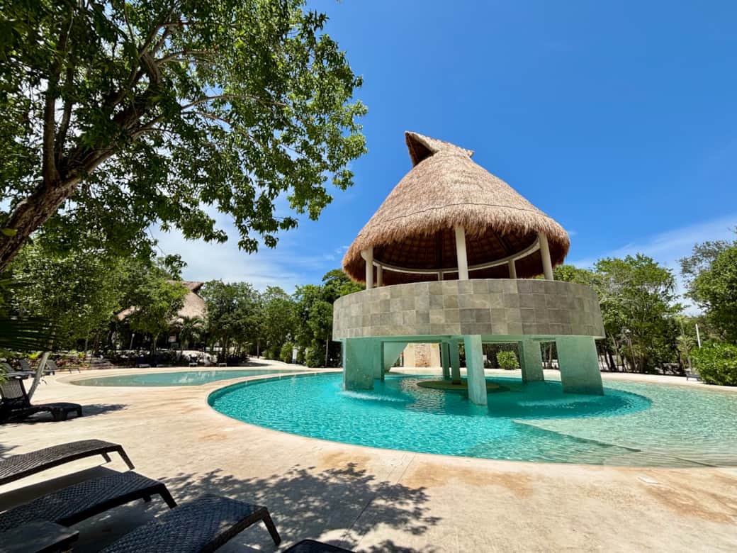 Common area with pools, palapas, hamocks, beach chairs and  tropical garden