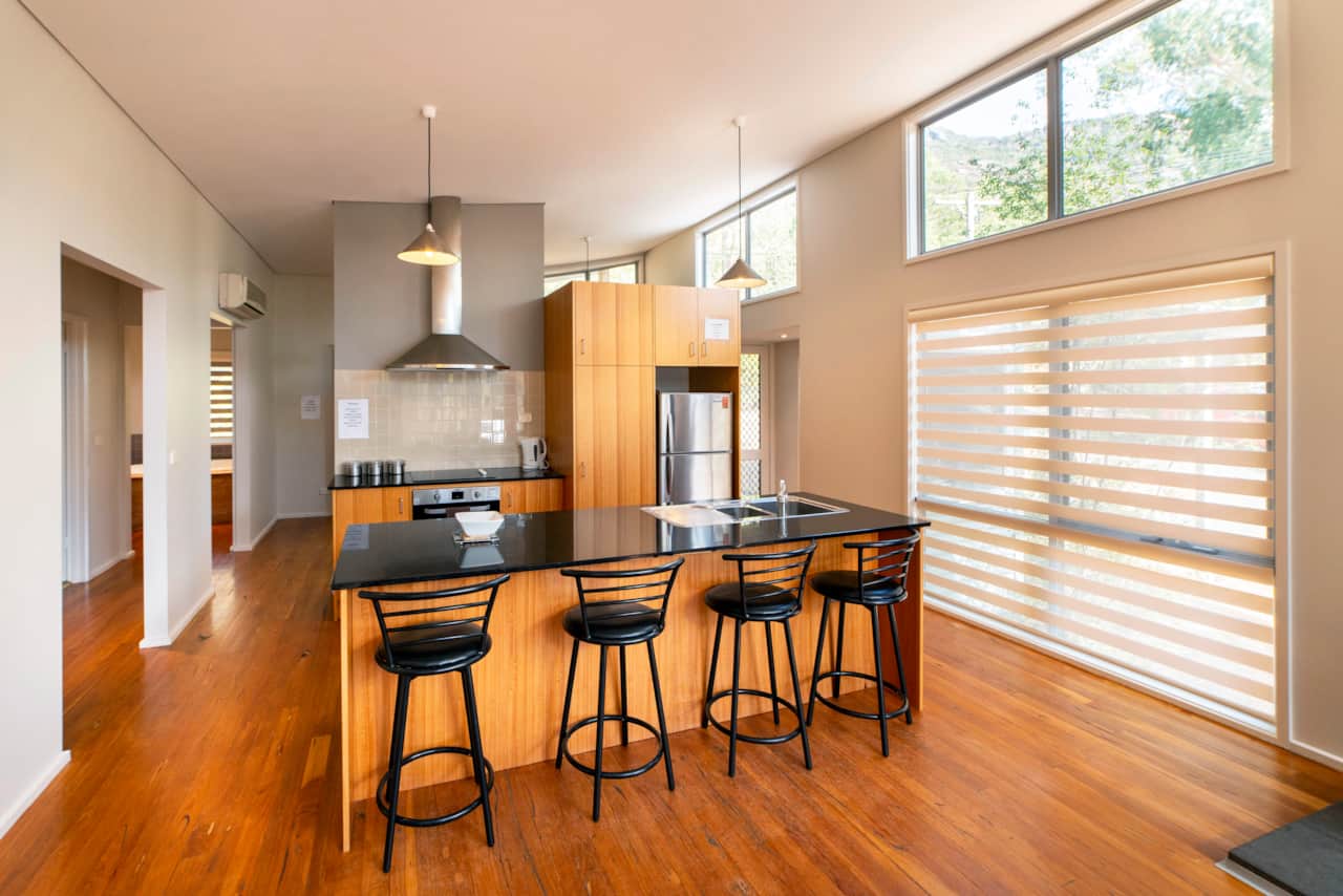 Heart of home: Sleek kitchen, modern amenities, four stylish bar stools. Culinary joy awaits! 