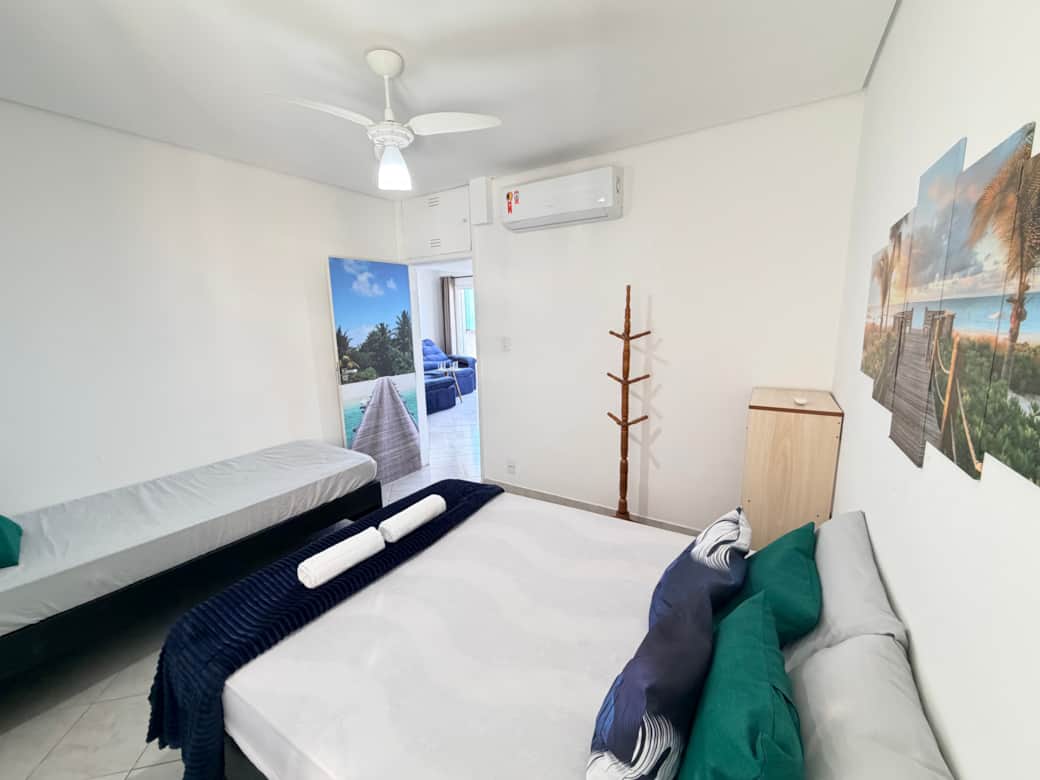 Quarto com cama de casal, cama de solteiro e ar-condicionado Split.