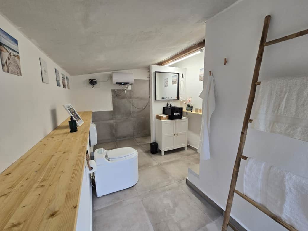 Modernes Badezimmer: Komfortable Ausstattung und stilvolles Design im Backsteinhaus.