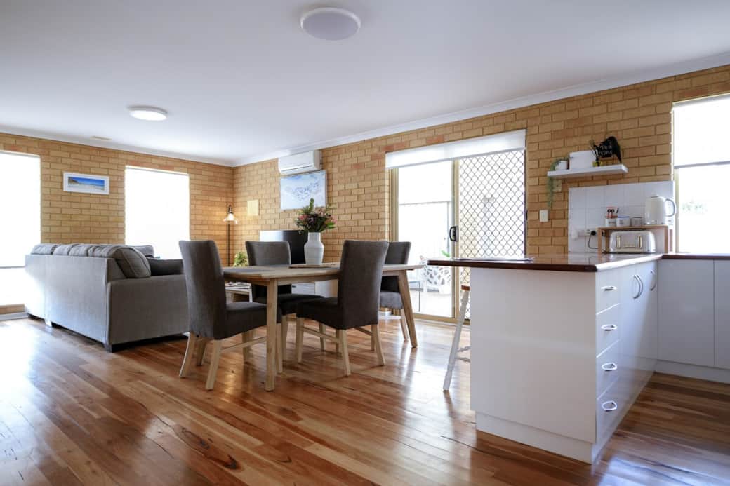 Dining and living area is located off the kitchen and opens to the rear outdoor space. A built-in doggy door in the sliding door suits small dogs.