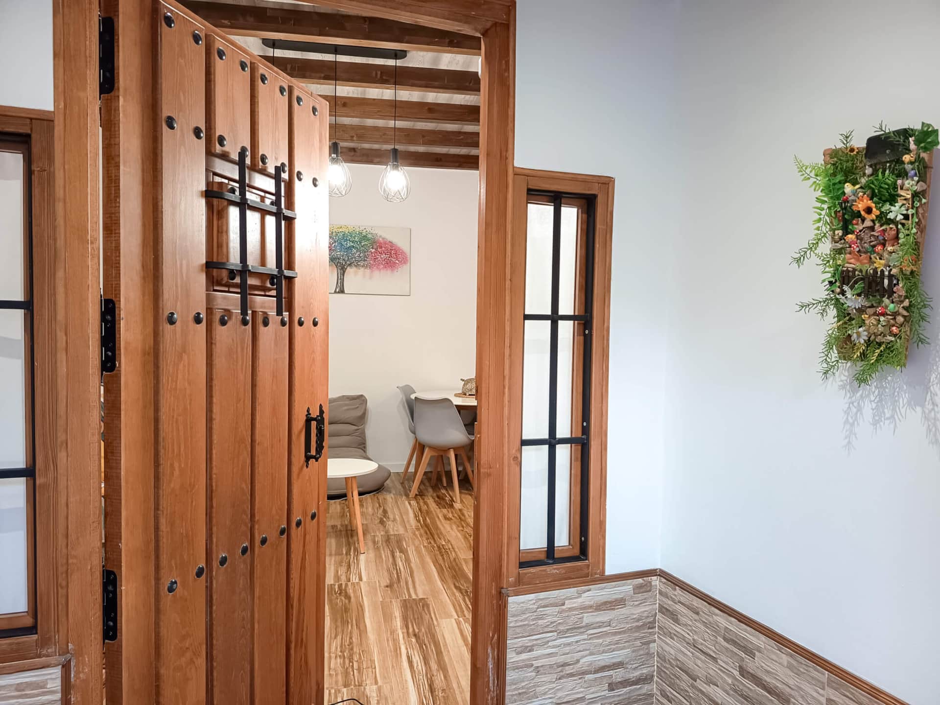 Entrada de La Casita de Ale en Polán con puerta de madera y acceso al salón