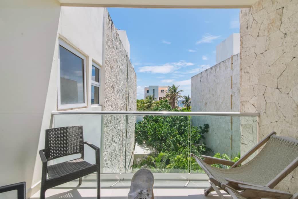 Private balcony with comfy outdoor seating and ocean vistas, perfect for coffee or evening drinks.
