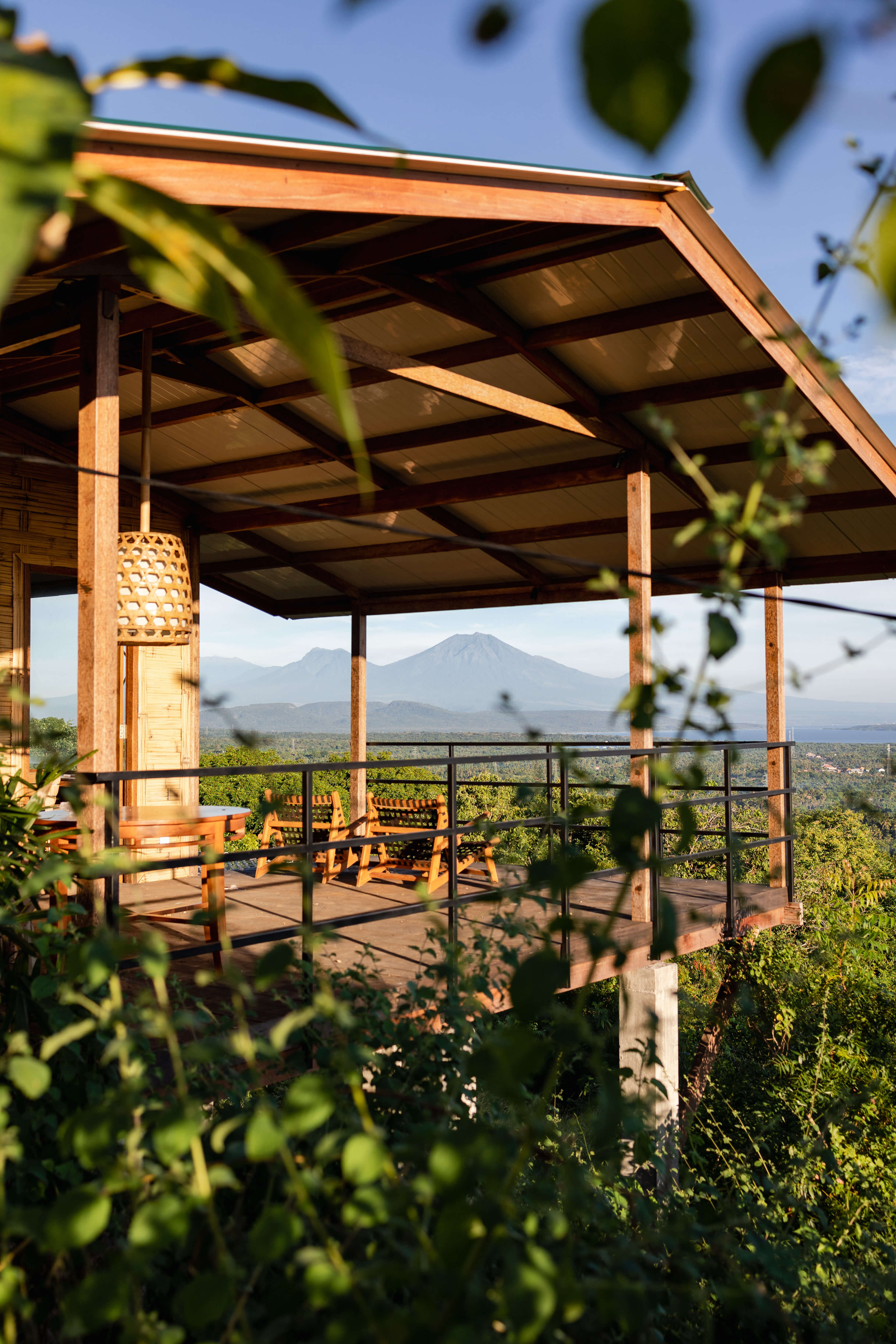 Cabin exterior view through tropical plants with volcanic mountain backdrop
