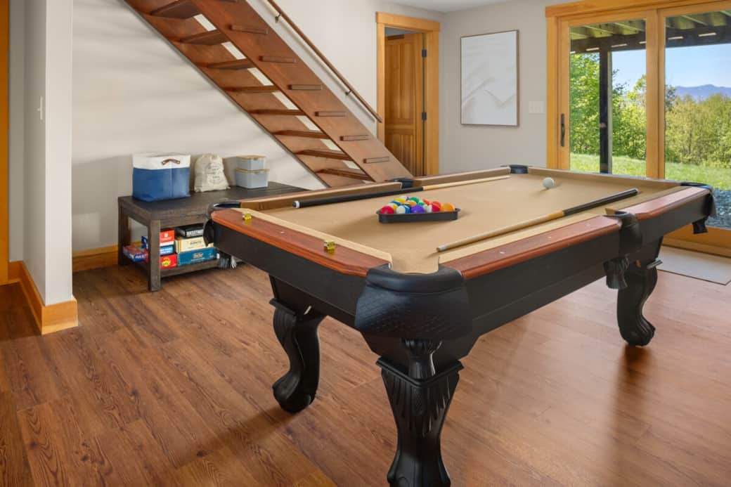 Game room with pool table and vintage Vermont ski art—perfect for friendly competition and après-ski vibes.
