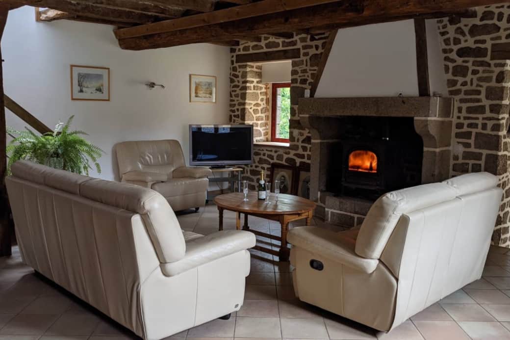 Salon confortable, cheminée et TV pour vos soirées et moments de détente