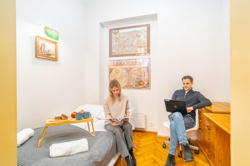 Comfortable bedroom with a cozy bed and a dedicated workspace, bright and well arranged.