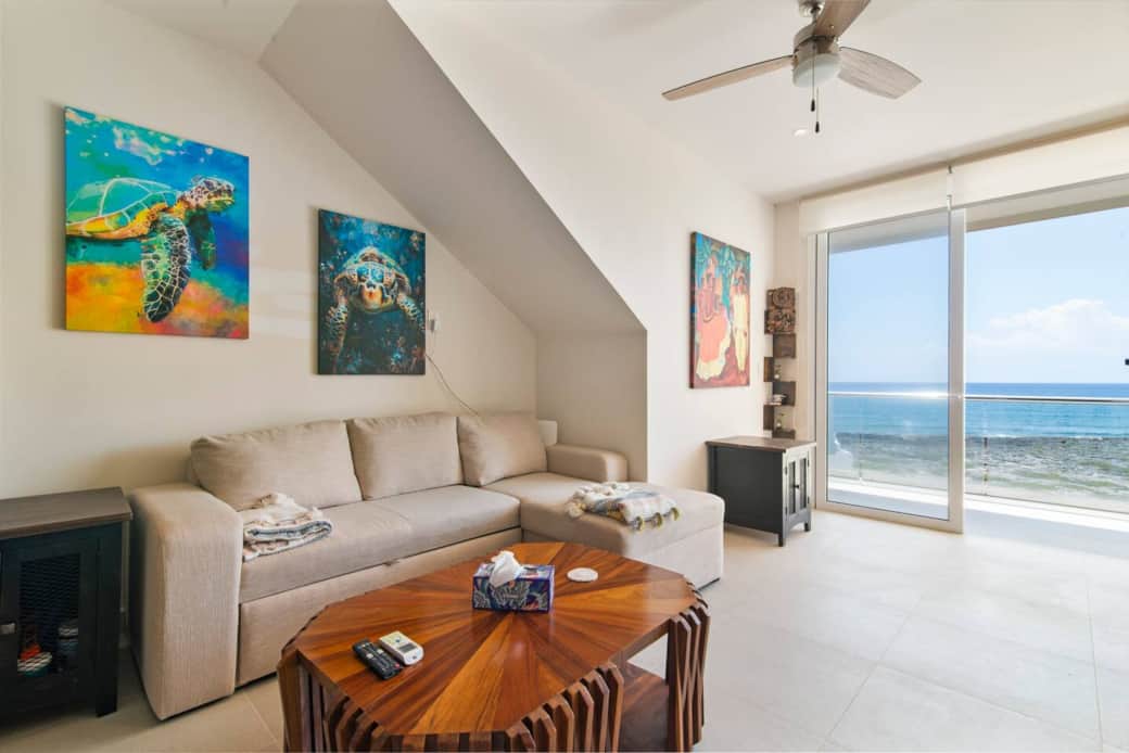 Cozy living room with ocean views, private balcony, and king-size sofa bed.