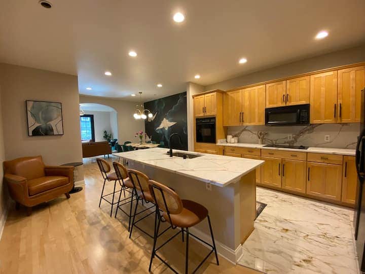Spacious and modern open-concept kitchen with a large marble island and ample seating.