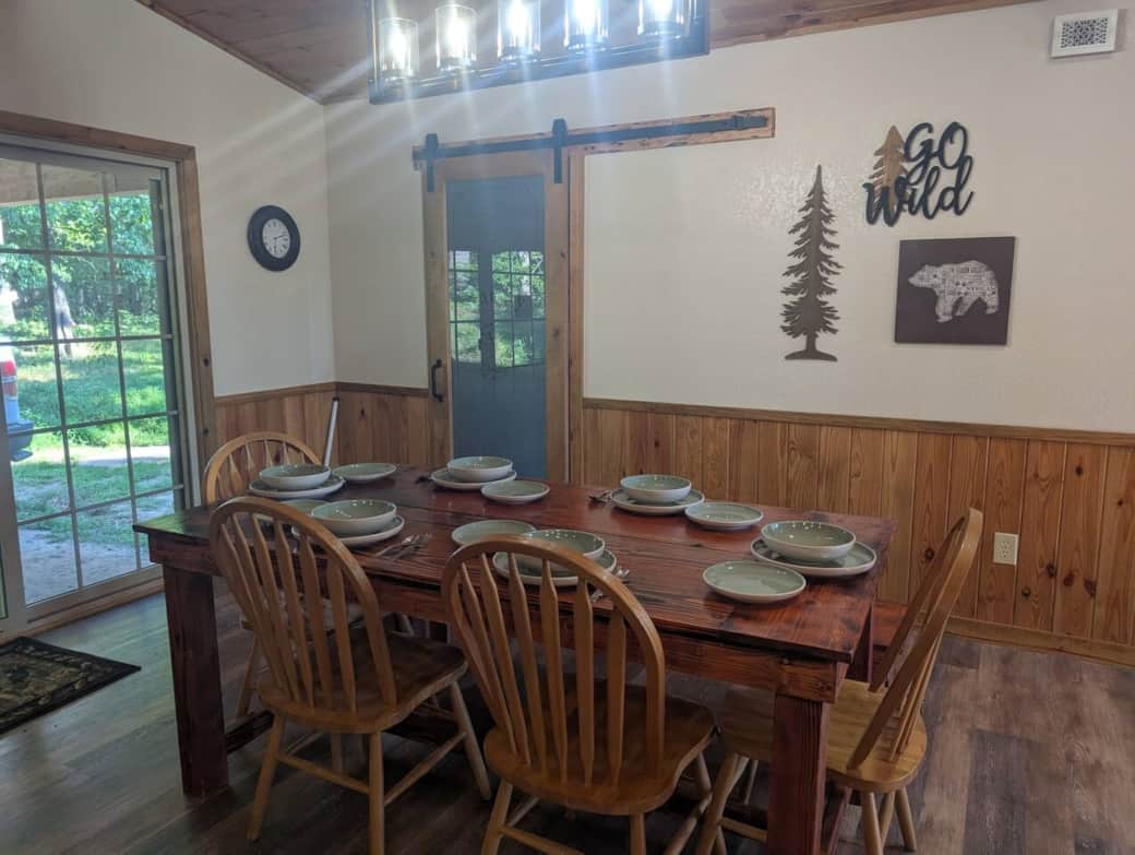 Dinning table with space for six. 4 chairs and a bench for 2. Place setting includes plate, salad or lunch plate and bowls. 